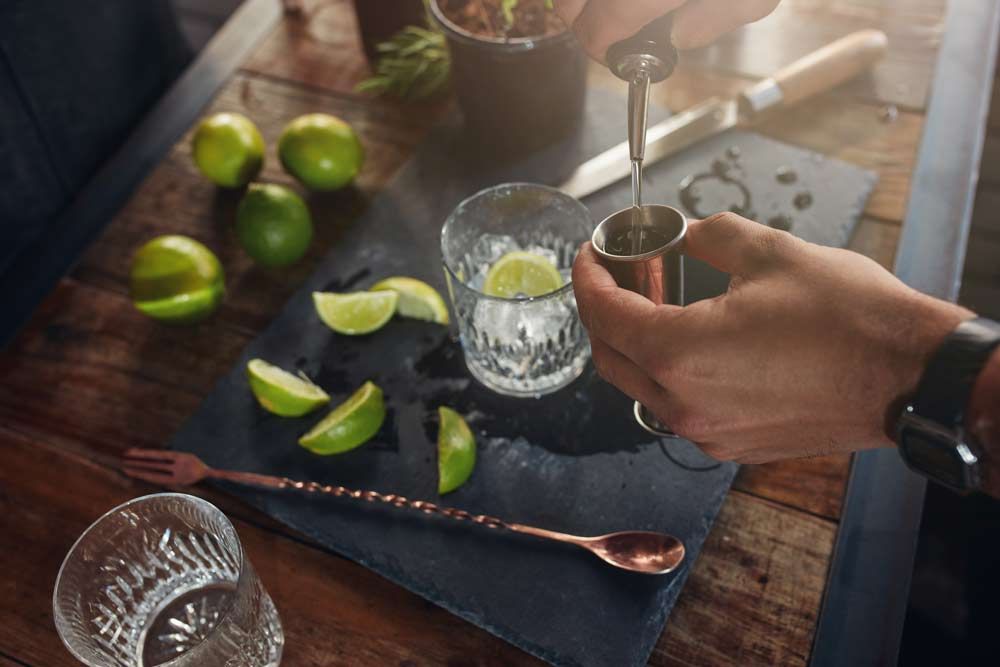 Pouring alcohol in jigger to prepare a cocktail