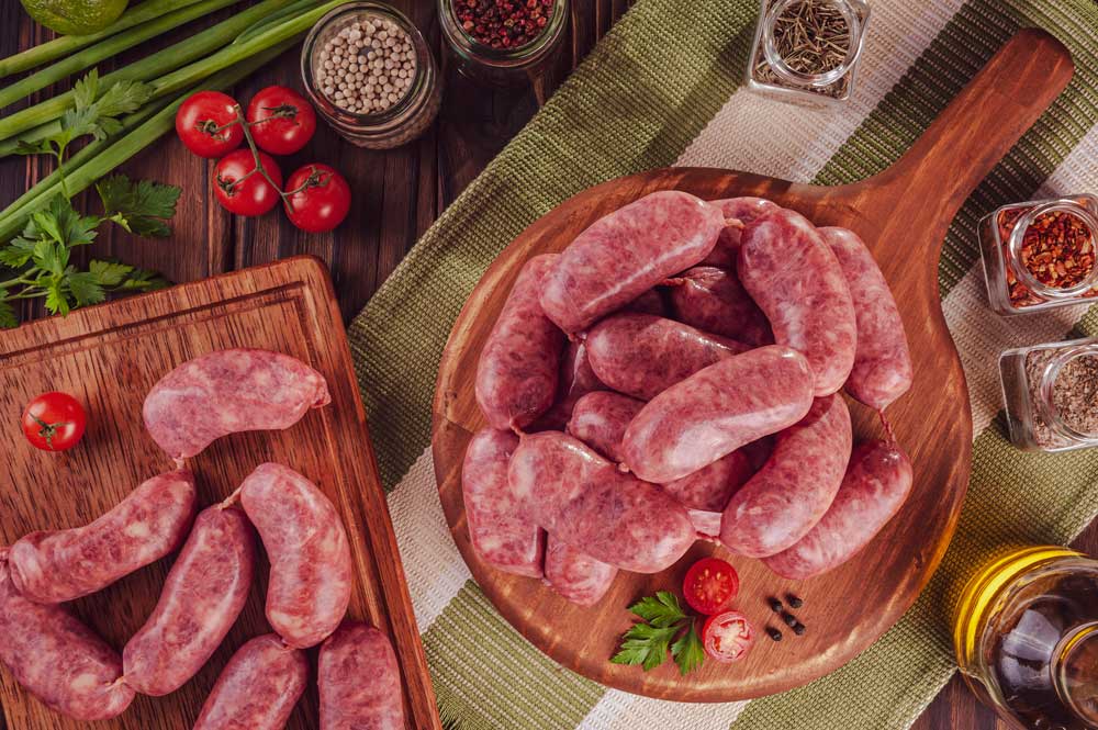 Raw brazilian sausages on the wooden board
