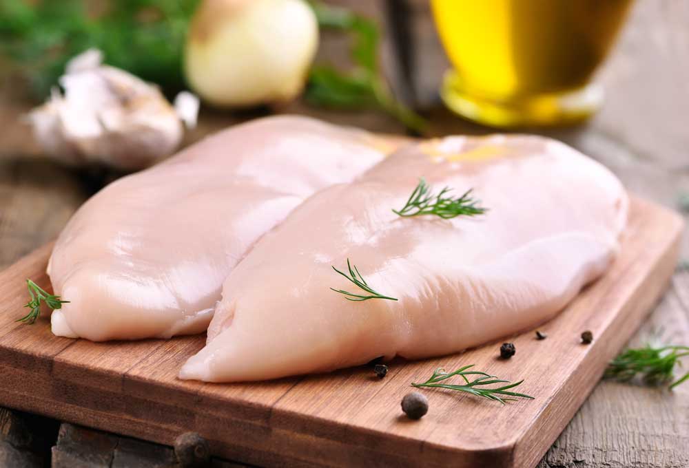 Raw-chicken-breasts-and-spices-on-wooden-cutting-board