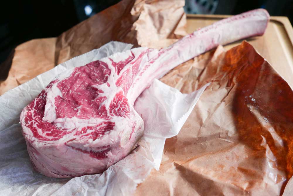 A large piece of meat is sitting on top of a piece of brown paper.