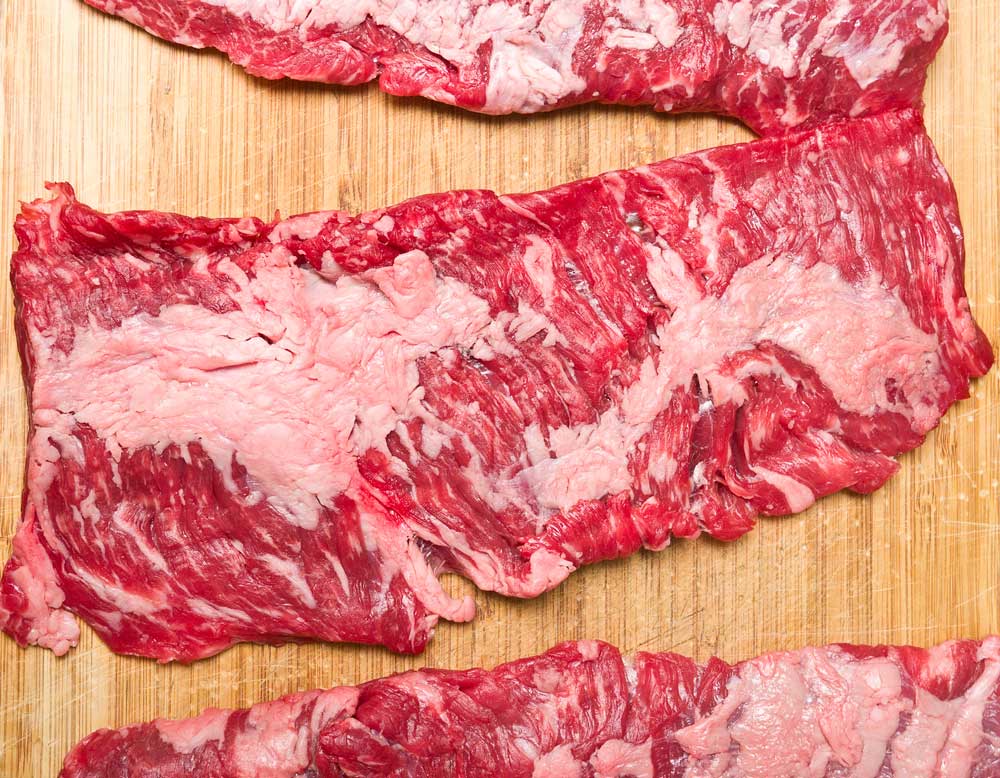 Skirt steak slices on wooden board