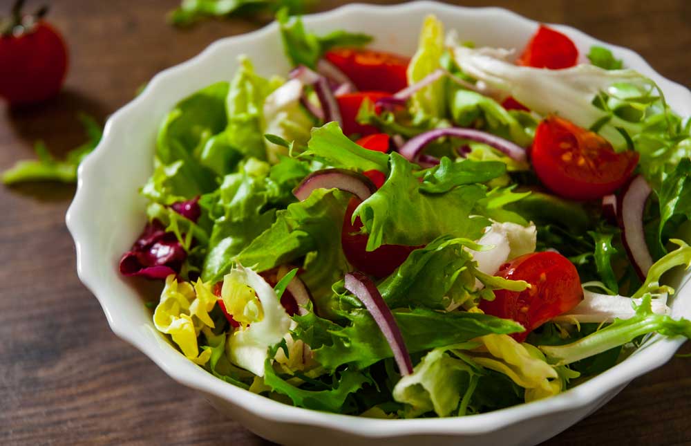 Various fresh mix salad leaves with tomato in bowl