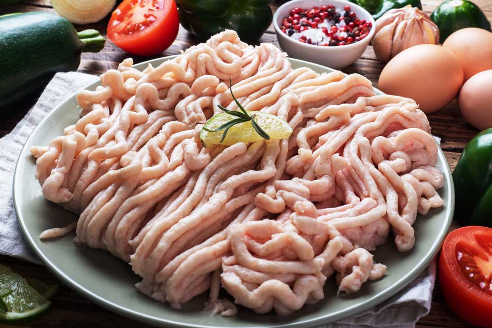 chicken on a plate with spices on a Wooden background and raw vegetables