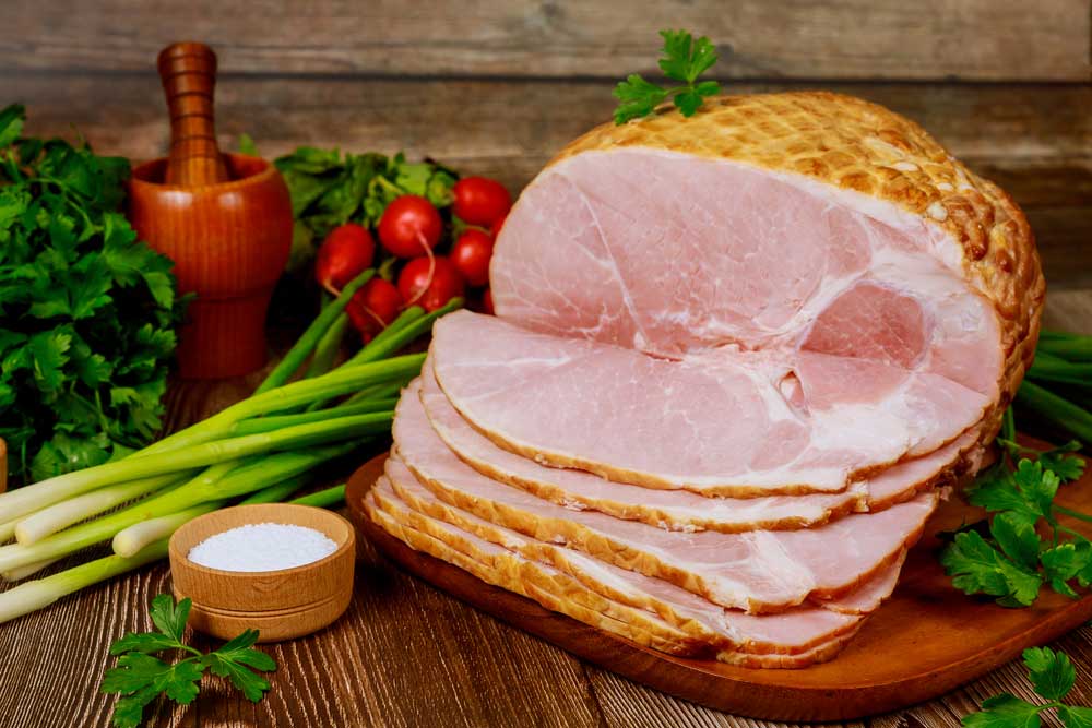 smoked-boneless-ham-with-vegetables-and-salt-on-wooden-table