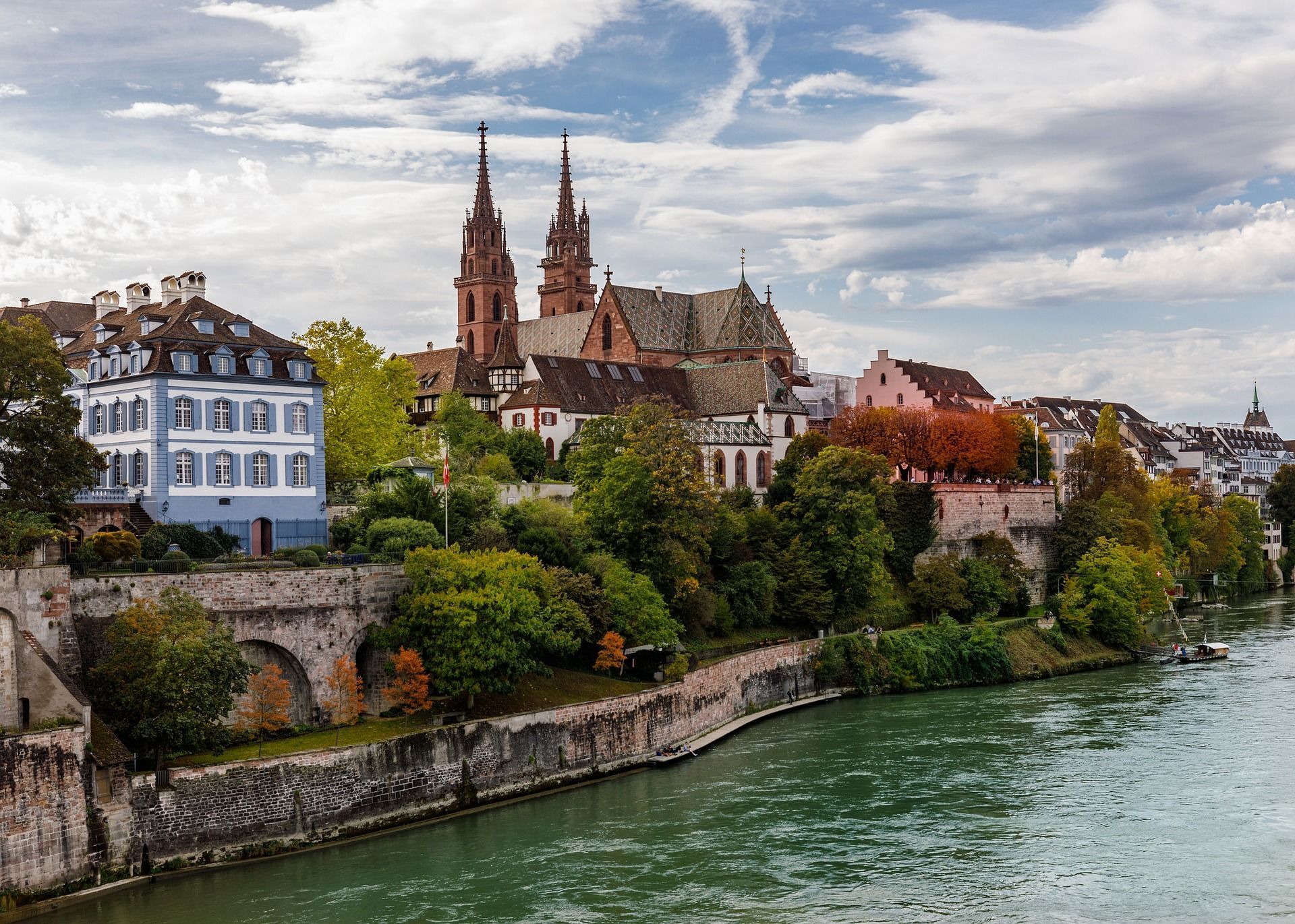A city along a river with a cathedral in the background.