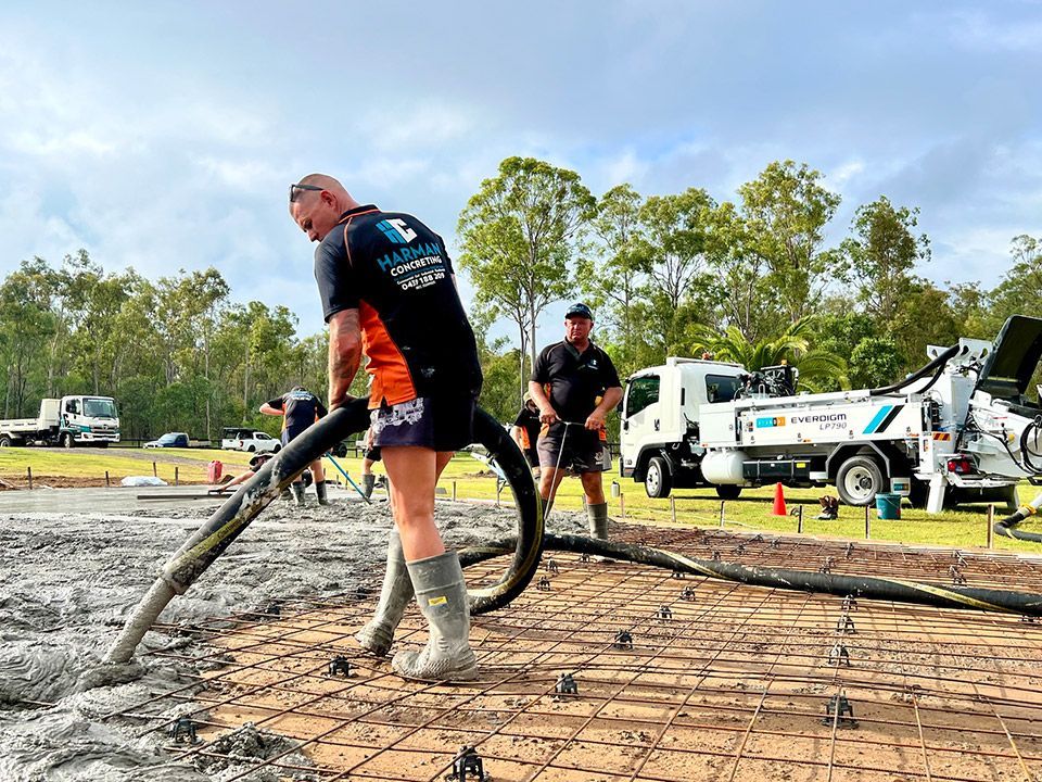 A man is pumping concrete with a hose on a construction site.