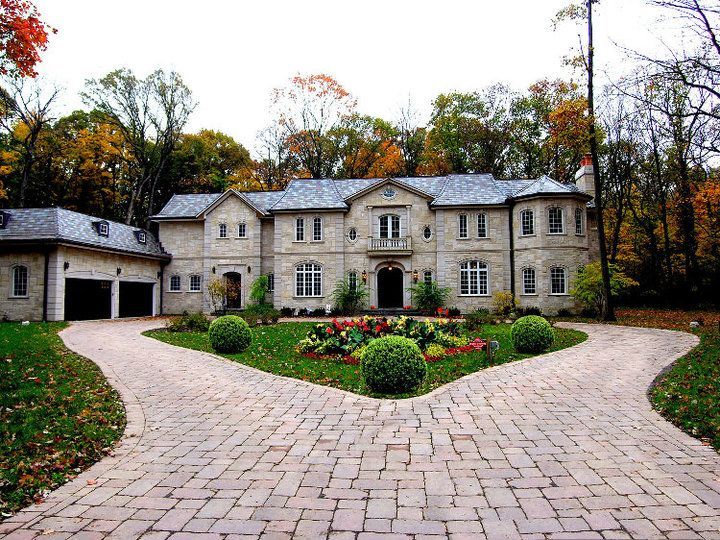 A large house with a brick driveway leading to it