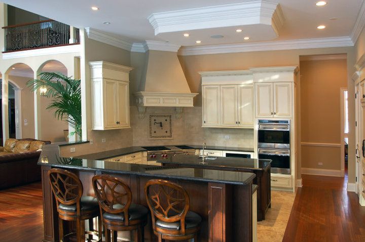 A kitchen in a house with a large island and stools.