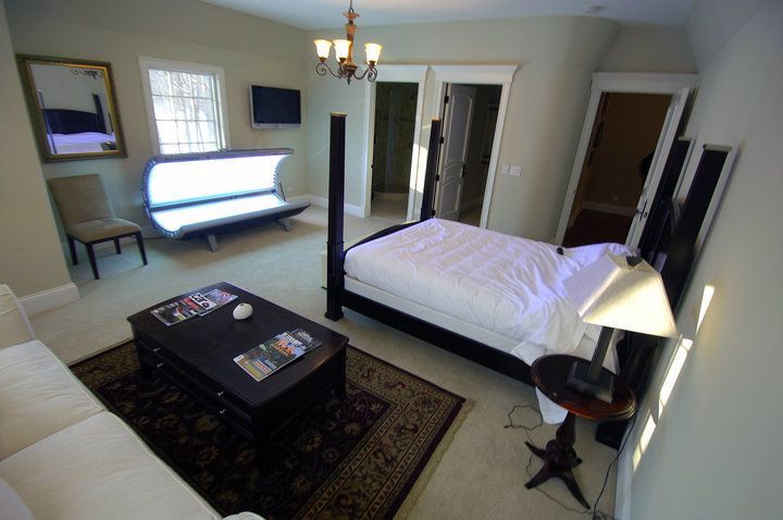 A bedroom with a bed and a tanning bed