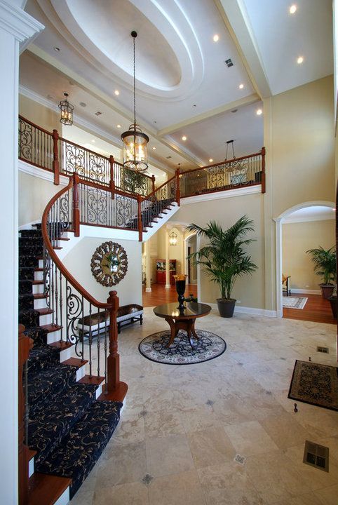 A large hallway with stairs and a clock on the wall