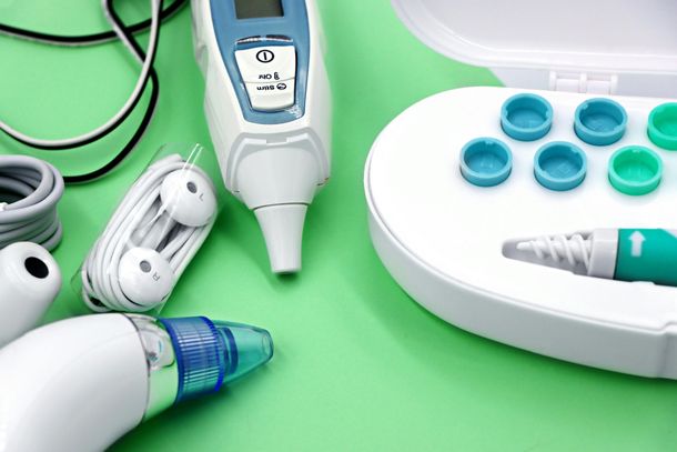 Electric toothbrush and oral care items on a green background with white-and-blue accessories