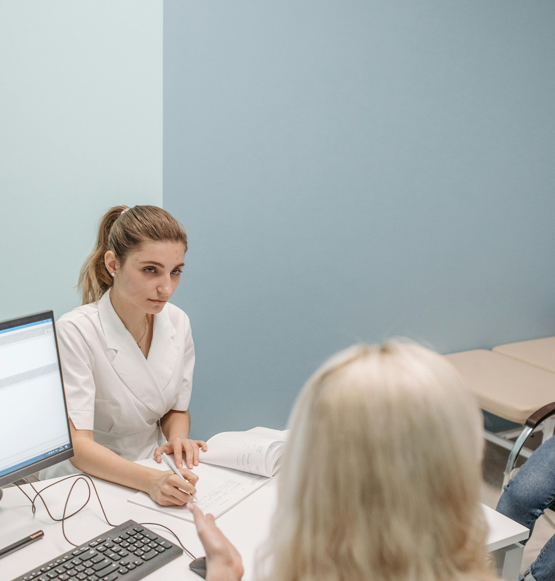 hearing specialist discussing something with a seated patient