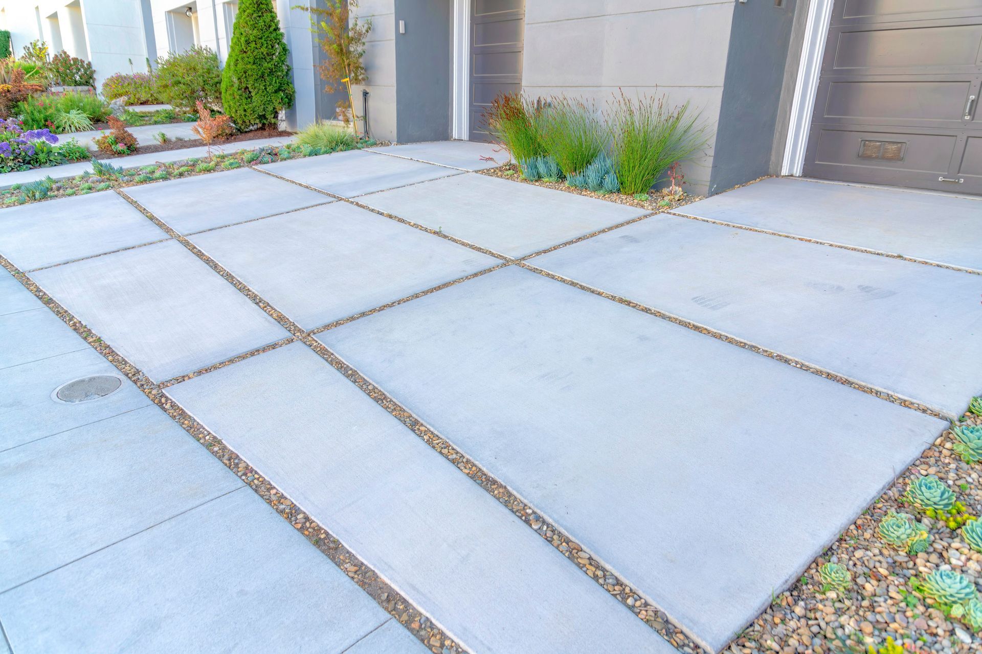 A concrete driveway in front of a house with a garage.