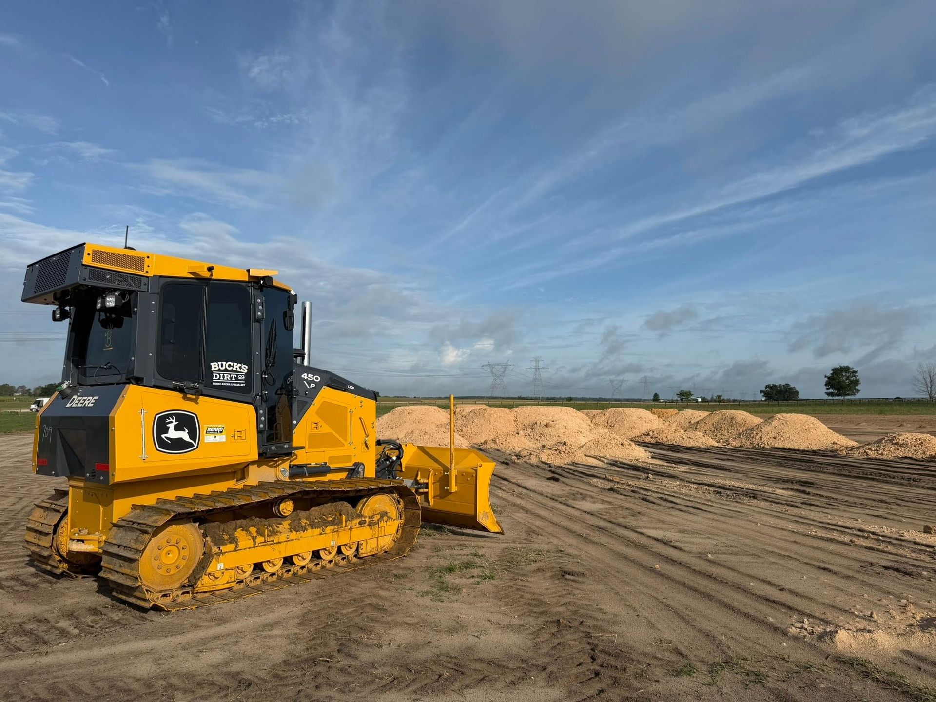 Yellow bulldozer on a dirt construction site under a blue sky
