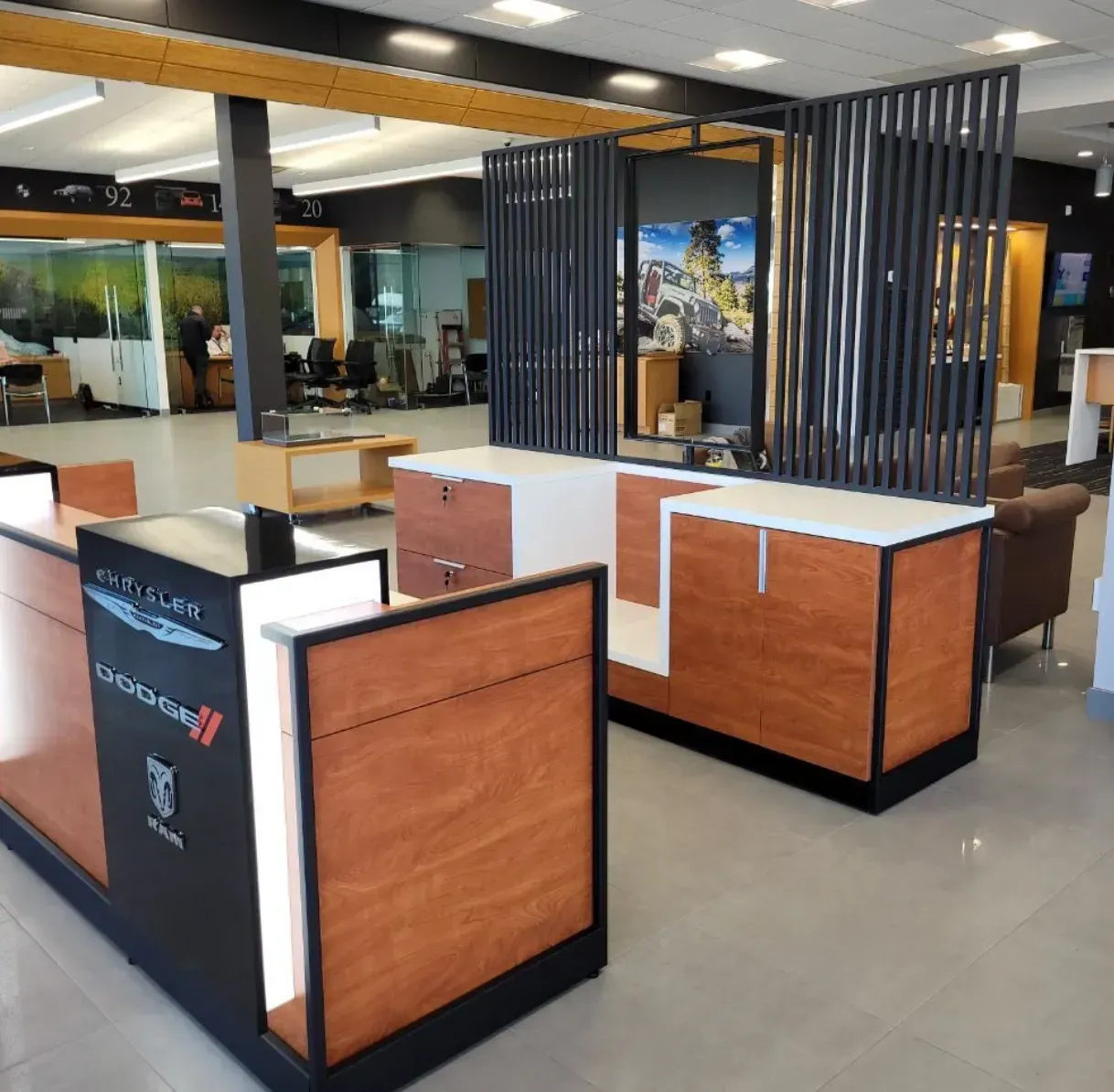 Modern lobby with wood-and-black reception desks and striped privacy partitions