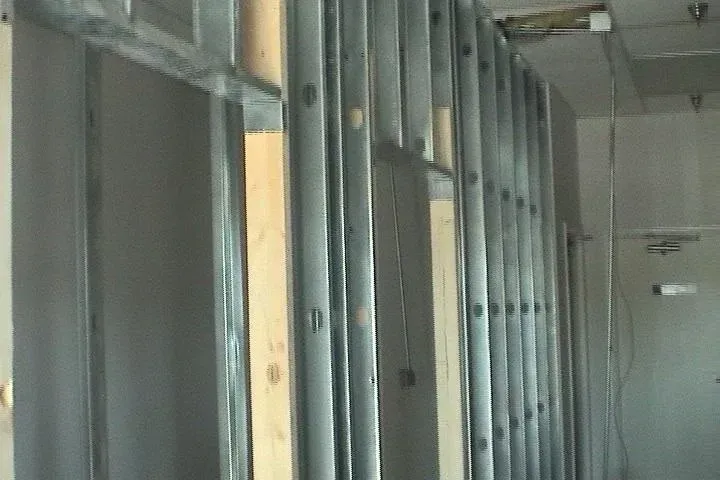 Unfinished interior hallway with exposed metal studs and drywall framing