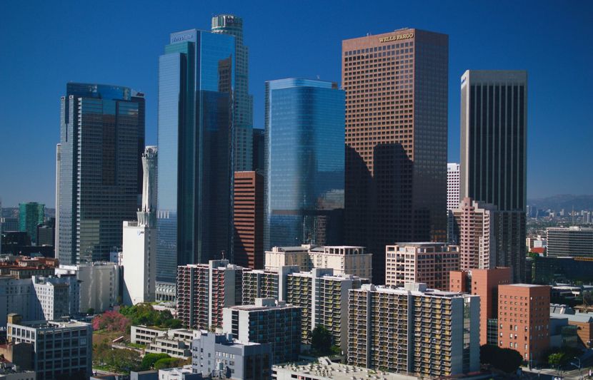 Downtown skyline with tall glass office towers and apartment buildings under a clear blue sky