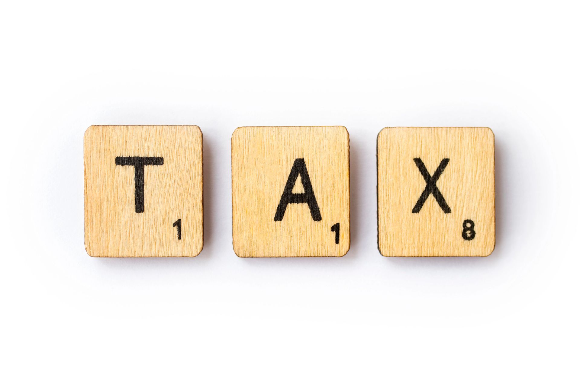 The word tax is written in scrabble tiles on a white background.