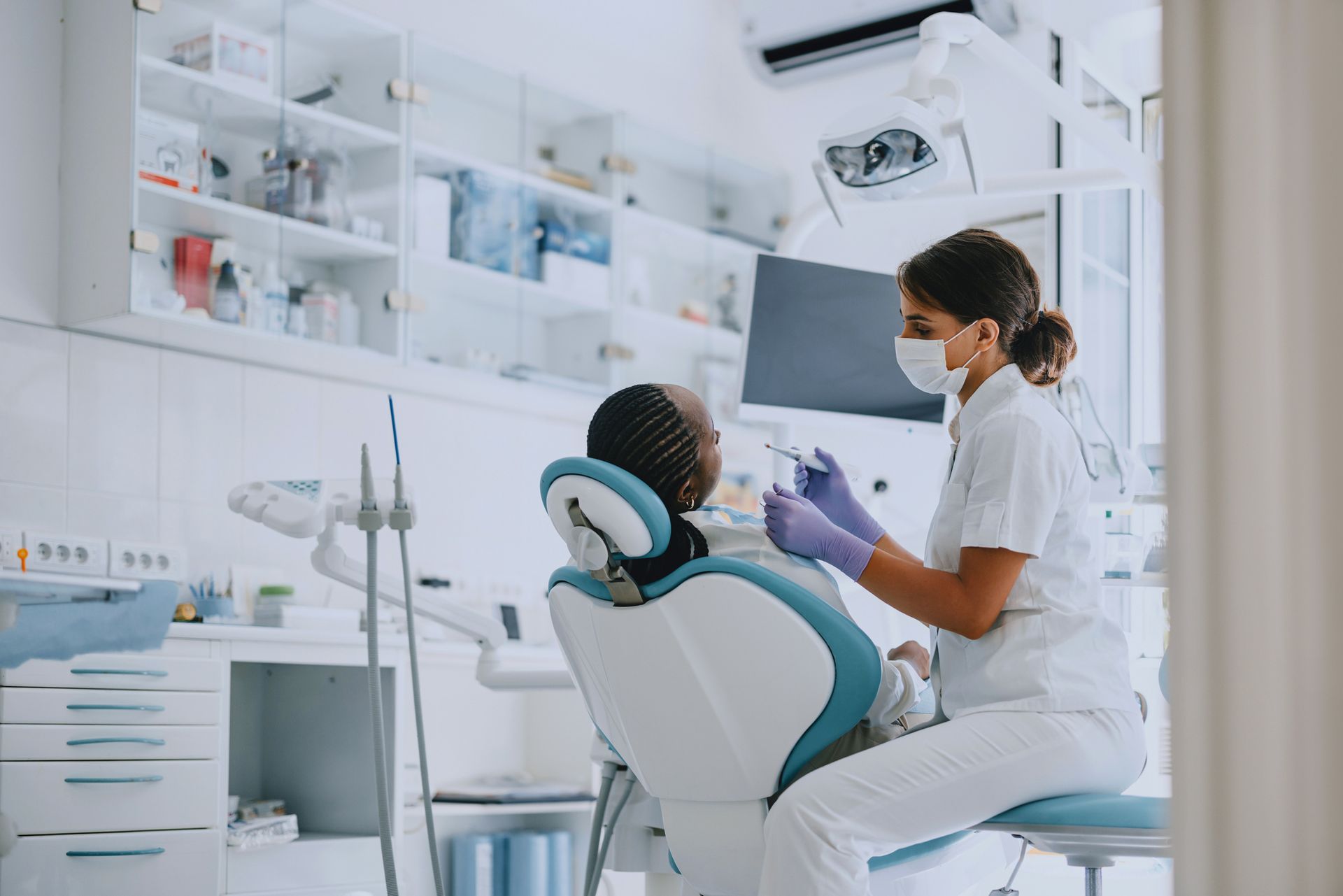 A dentist is examining a patient 's teeth with a dental probe.
