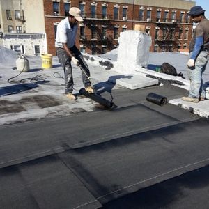 Two men are working on a roof with the number 51 on the side of the building