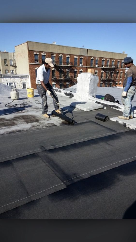 Two men are working on the roof of a building