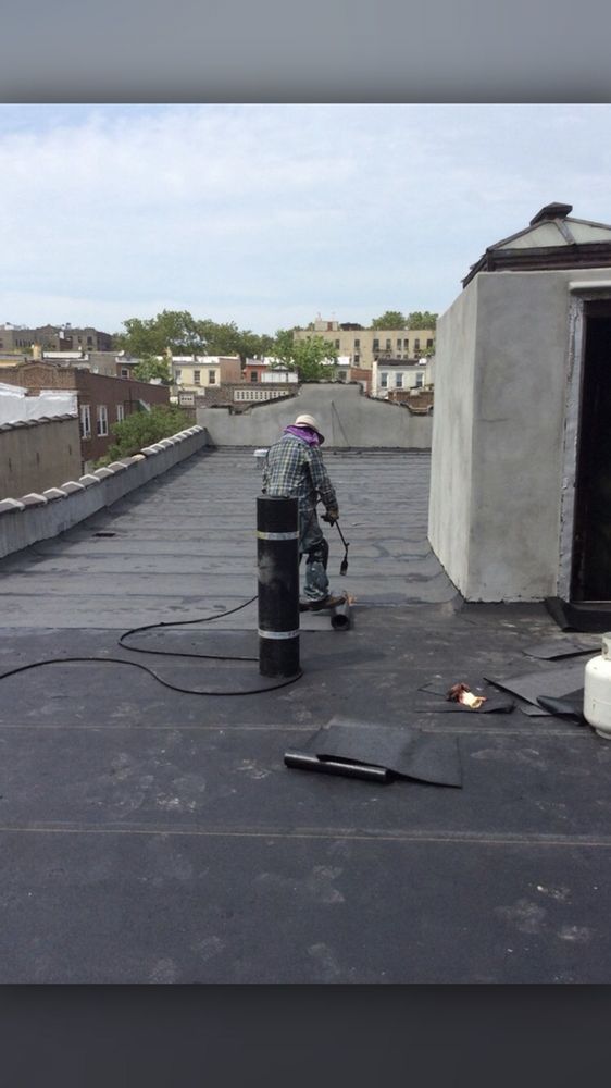 A man is working on the roof of a building.