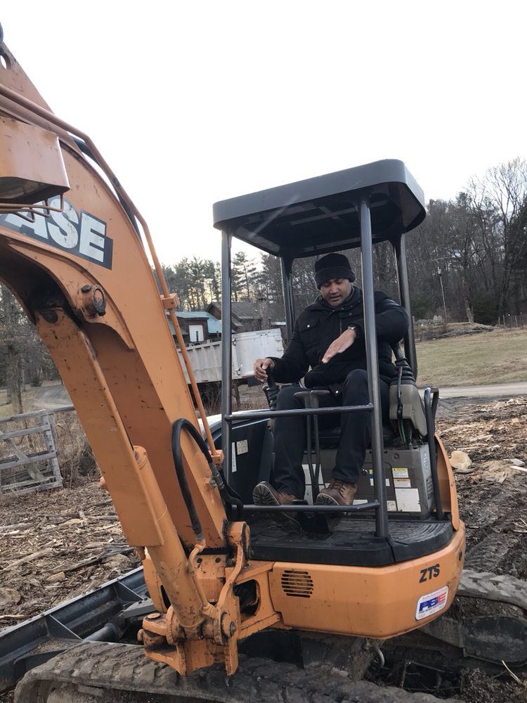 A man is sitting in the driver 's seat of a case excavator.