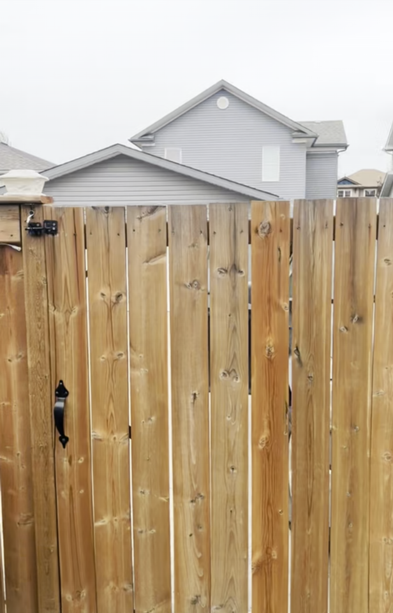 A wooden fence with a house in the background