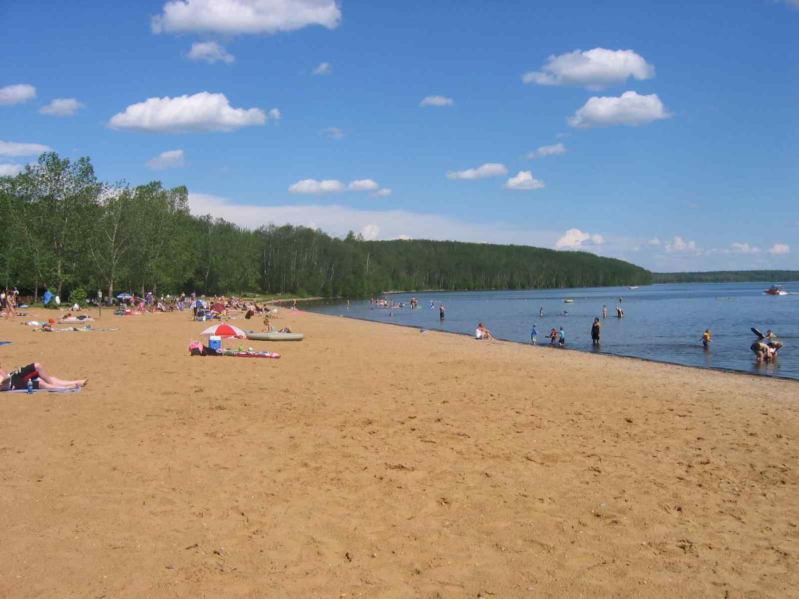 A sandy beach with a lake in the background