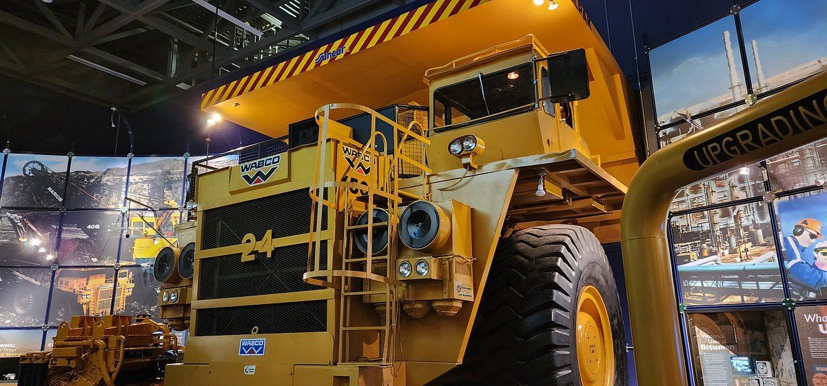 A large yellow dump truck is sitting in a room.