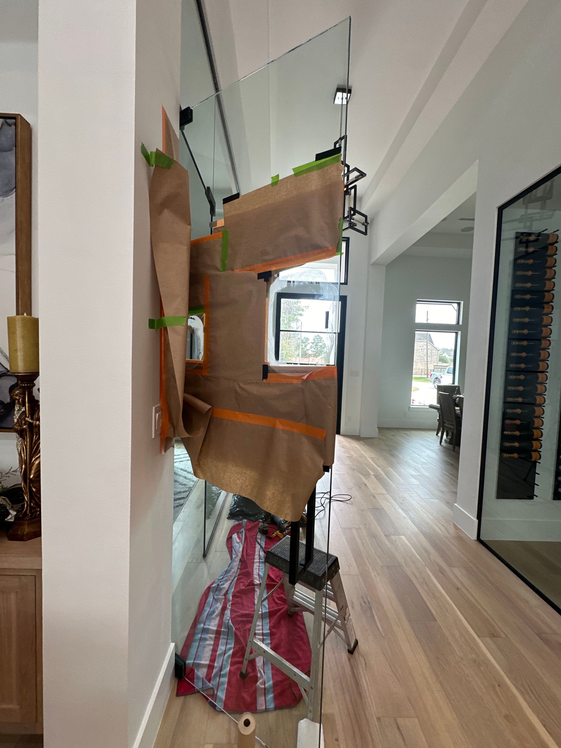 Hallway with a leaning mirror, cardboard-covered shelf, and a red striped bag on the floor