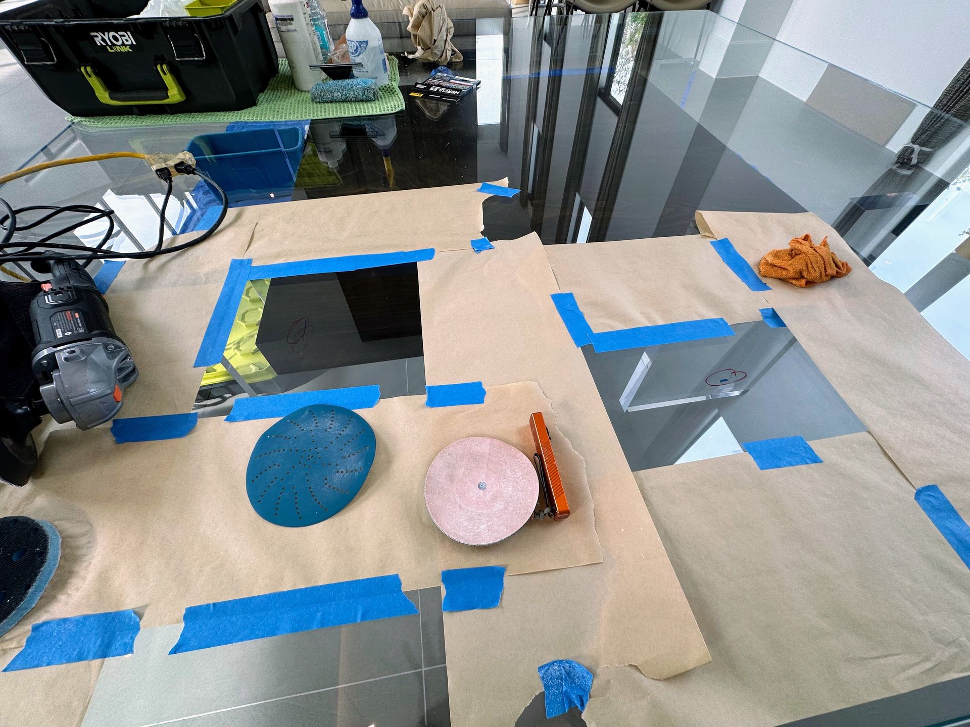 Cardboard tabletop maze with blue tape, two colored bowls, and a small toy on a desk