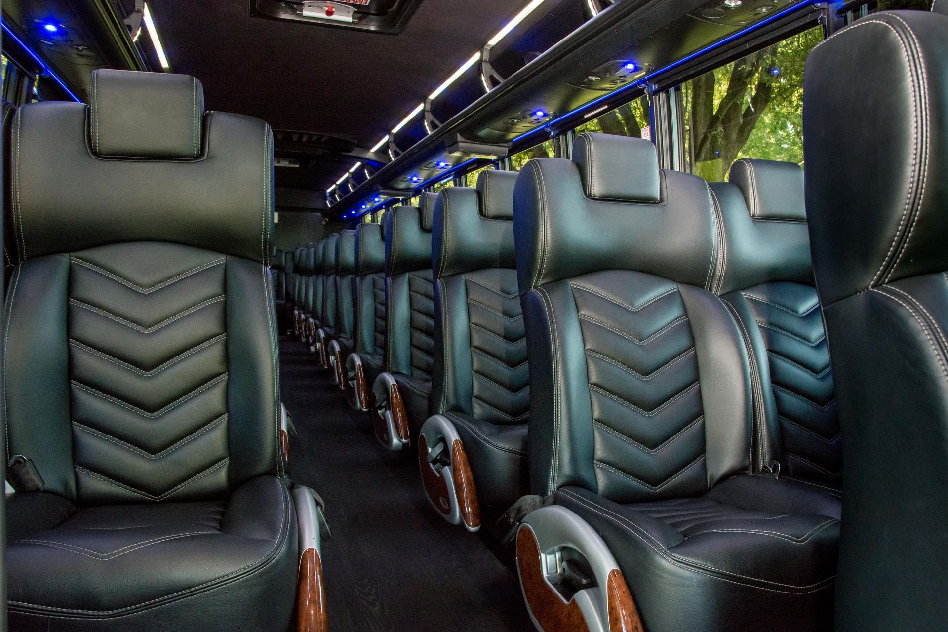 A row of black leather seats on a bus
