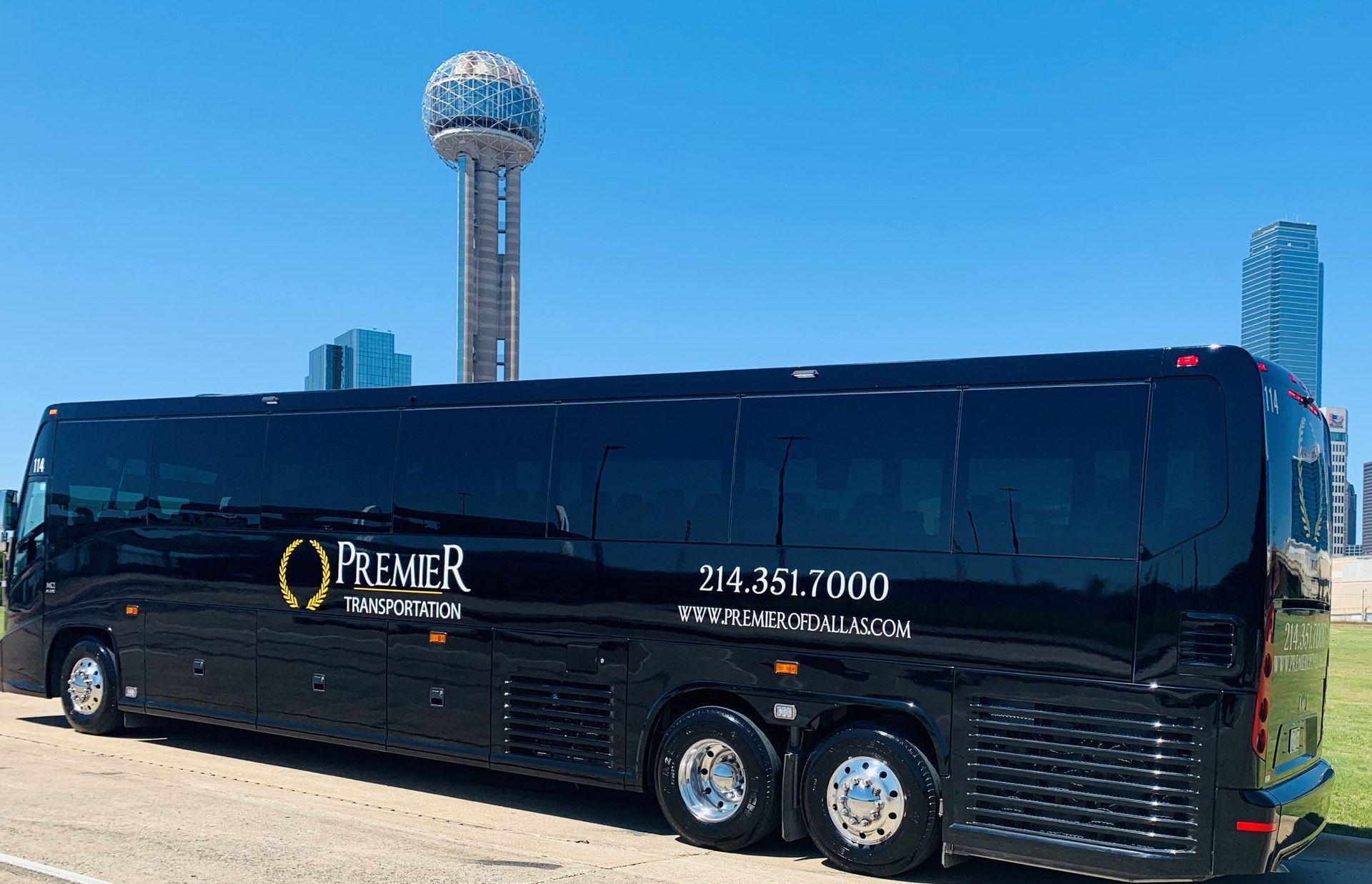 A large black bus is parked on the side of the road.