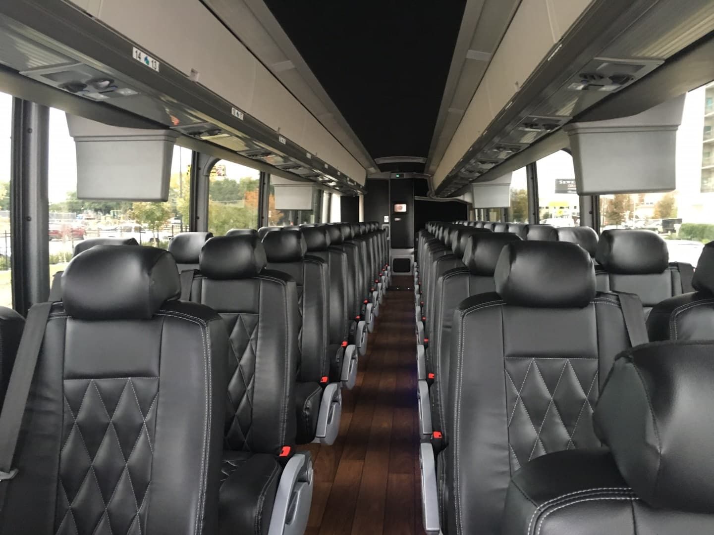 The inside of a bus with a lot of black seats.