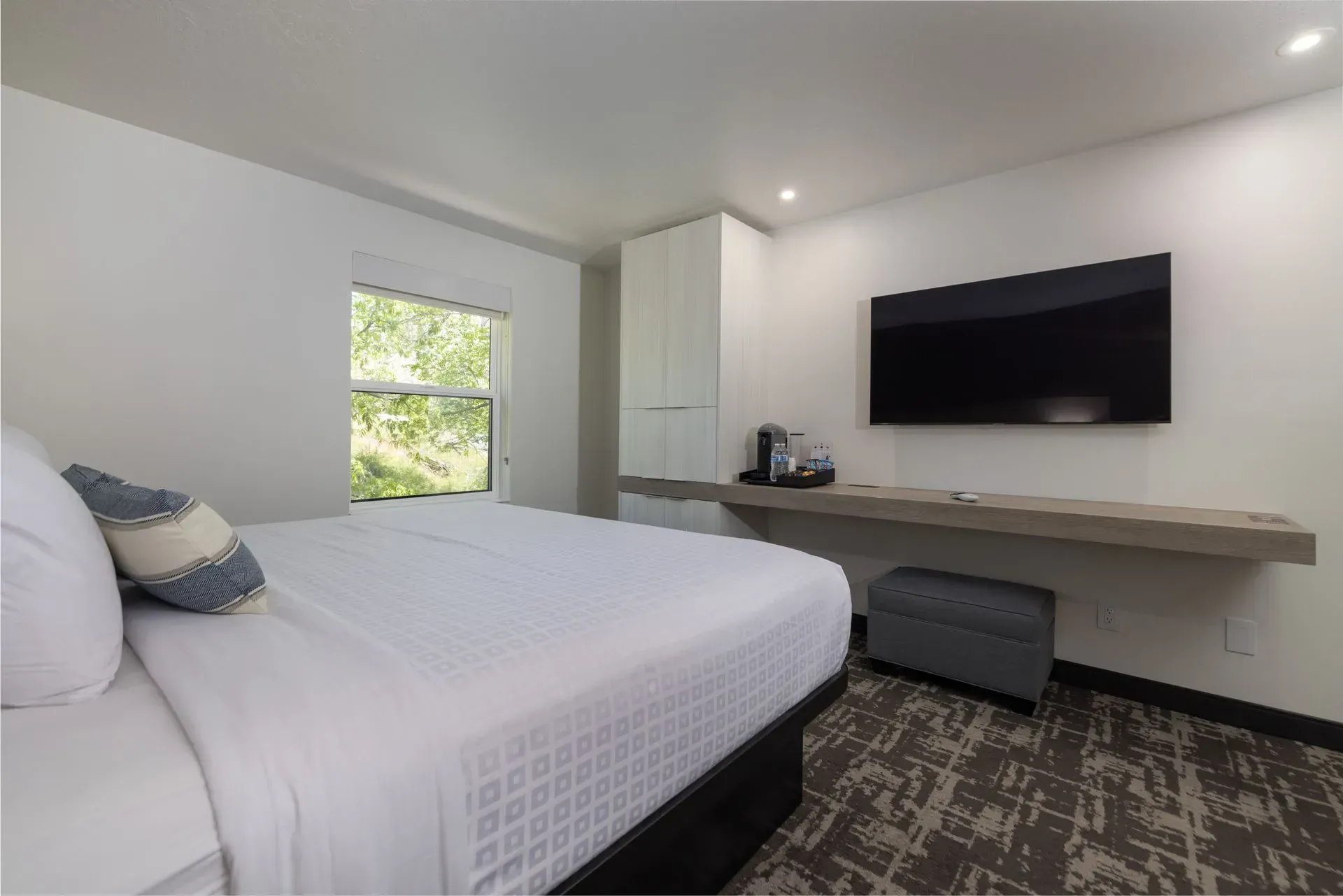 A hotel room with a king size bed and a flat screen tv.