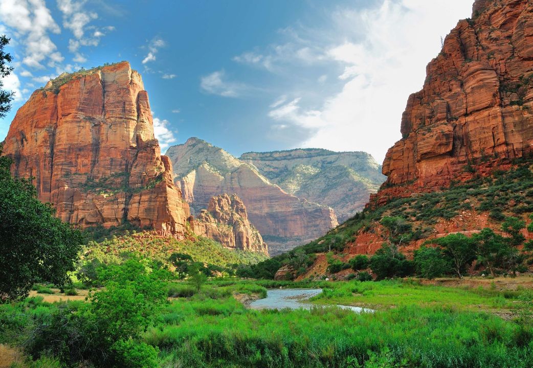 A waterfall is surrounded by rocks and trees in the middle of a canyon.