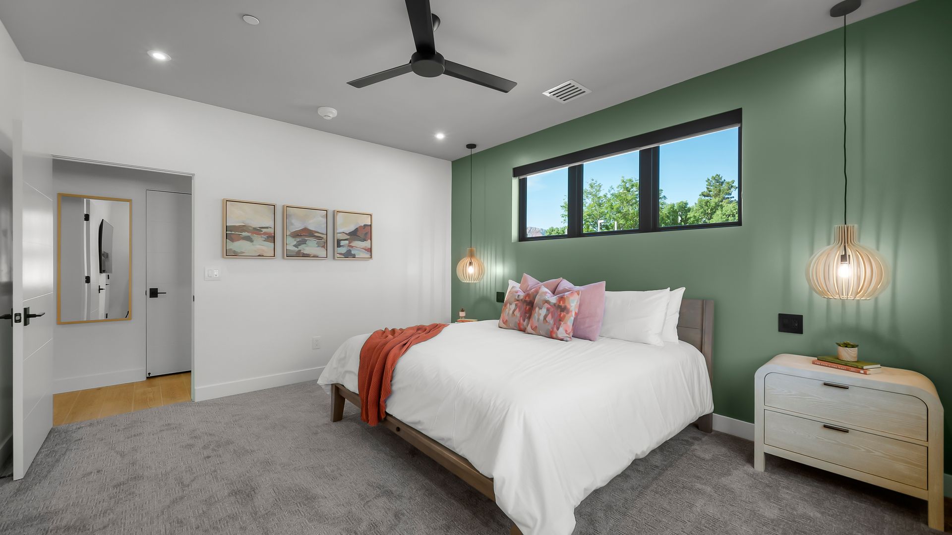 Bedroom with white walls, a green accent wall, bed, nightstand, and window.