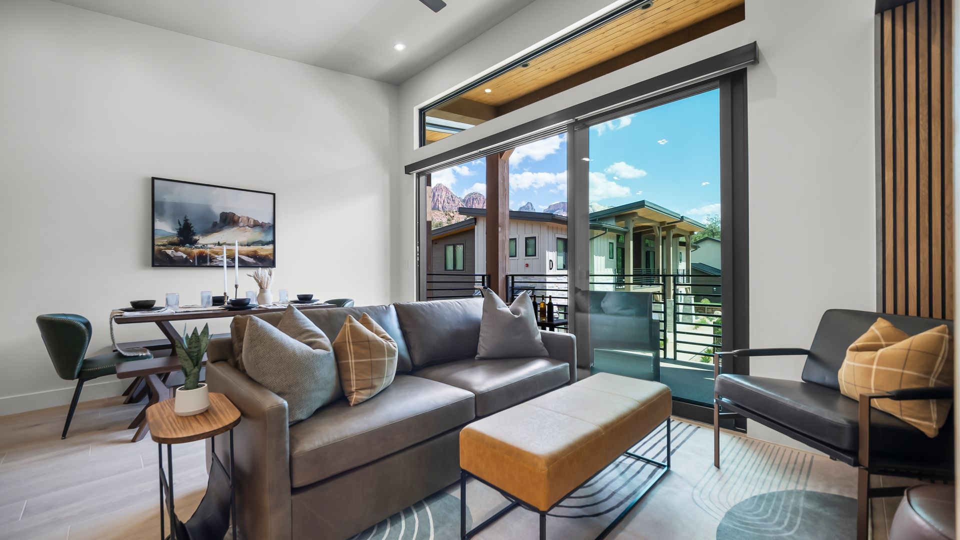 Living room with gray sofa, black chair, and large sliding glass door to a balcony.