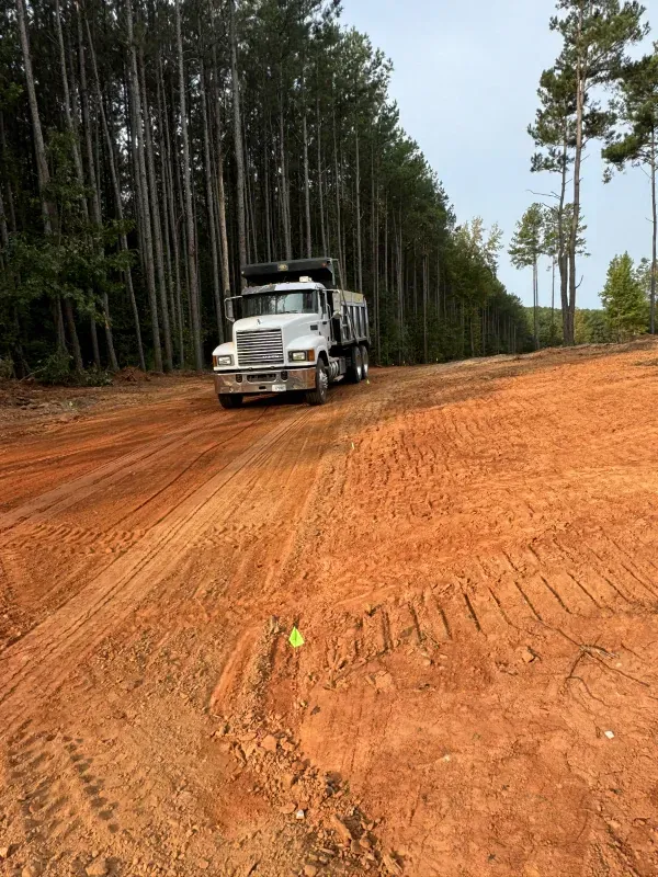Construction site: bulldozer grading earth. Excavation for a pond with orange safety netting