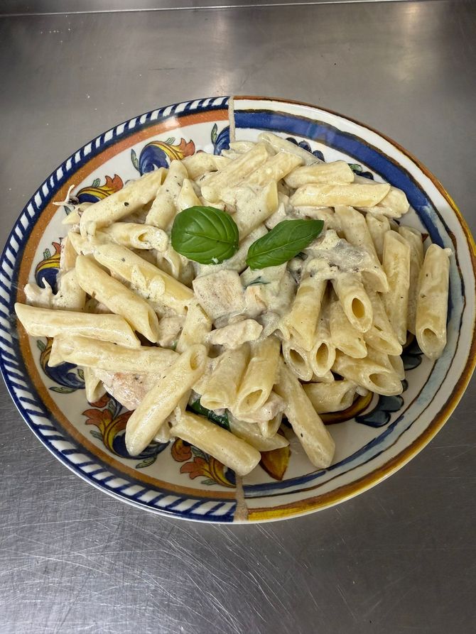 Focaccia condita con formaggio bianco, pomodorini e foglie di basilico fresco.