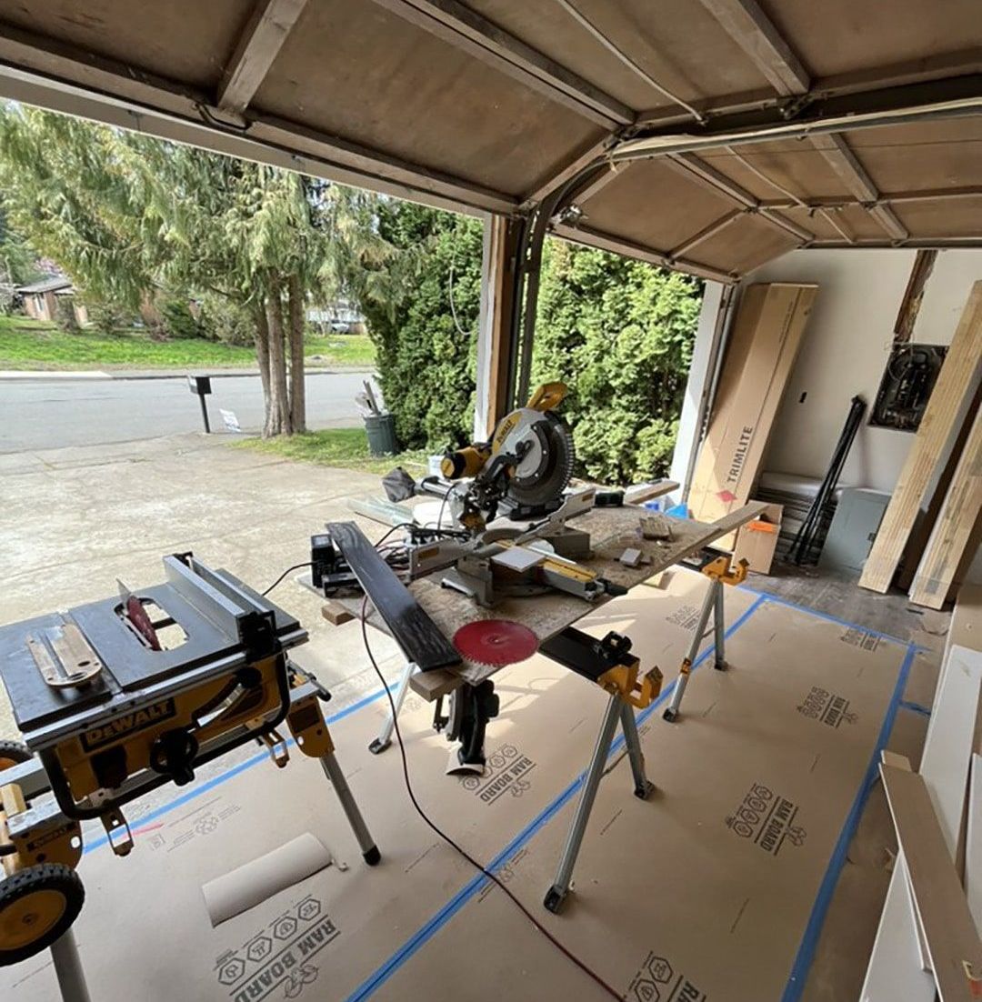 A garage with a table saw and a circular saw in it.