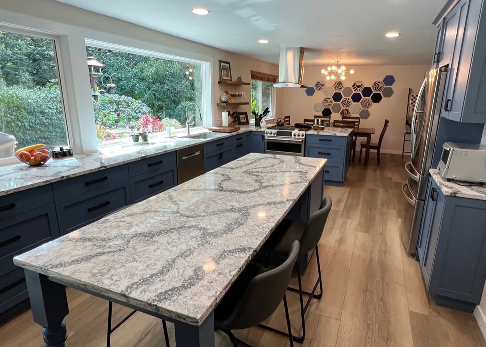 Blue kitchen with granite countertops, island with stools, and a dining area. Blue kitchen with granite countertops, island with stools, and a dining area.