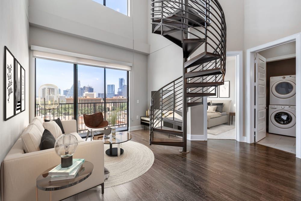A living room with a spiral staircase leading to the second floor at Water's Edge.
