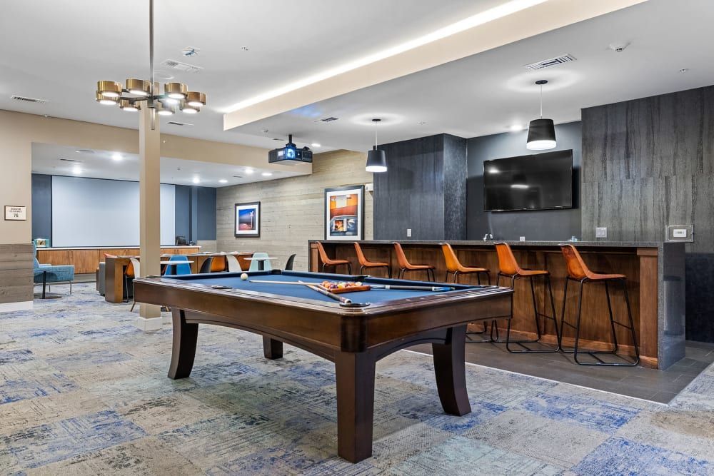 There is a pool table in the middle of the room at Water's Edge.