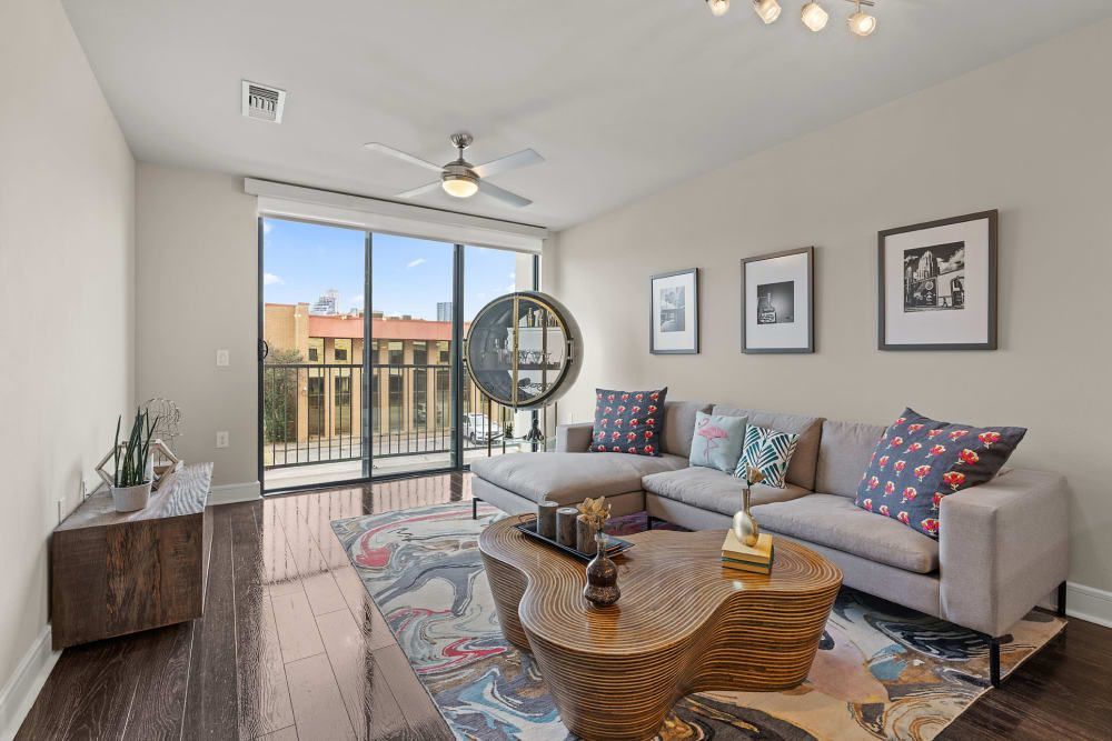 A living room with a couch , coffee table , and balcony at Water's Edge.