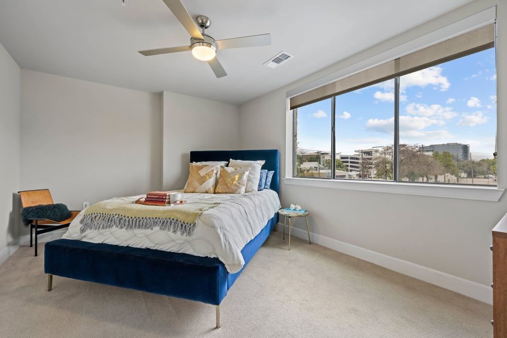 A bedroom with a bed and a ceiling fan at Water's Edge.