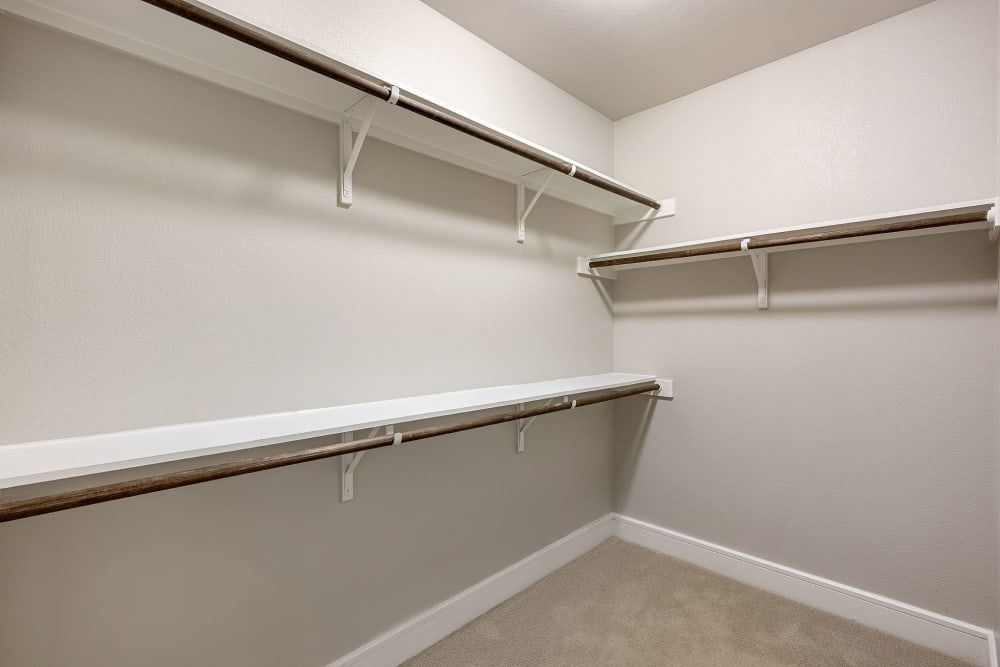 An empty walk in closet with shelves and clothes racks at Water's Edge.