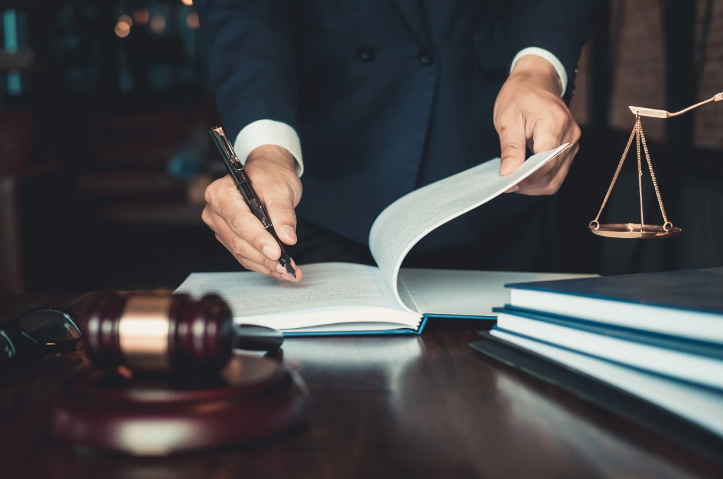A judge is writing on a piece of paper while sitting at a desk.