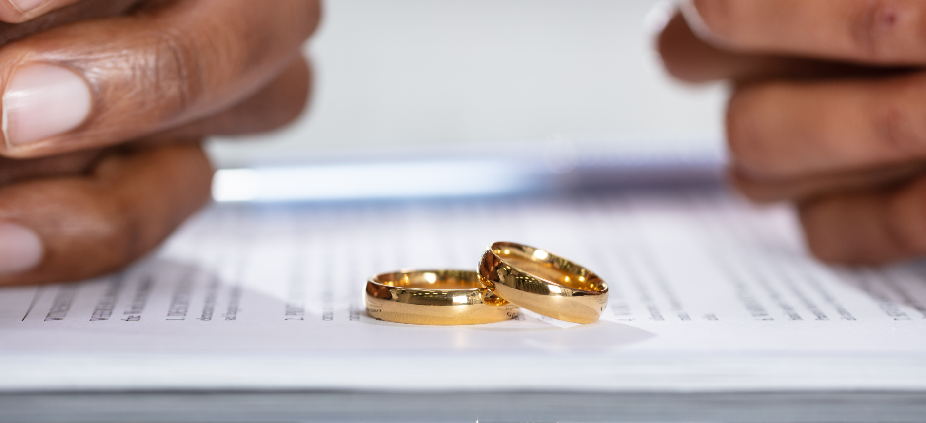 A couple of wedding rings are sitting on top of a piece of paper.